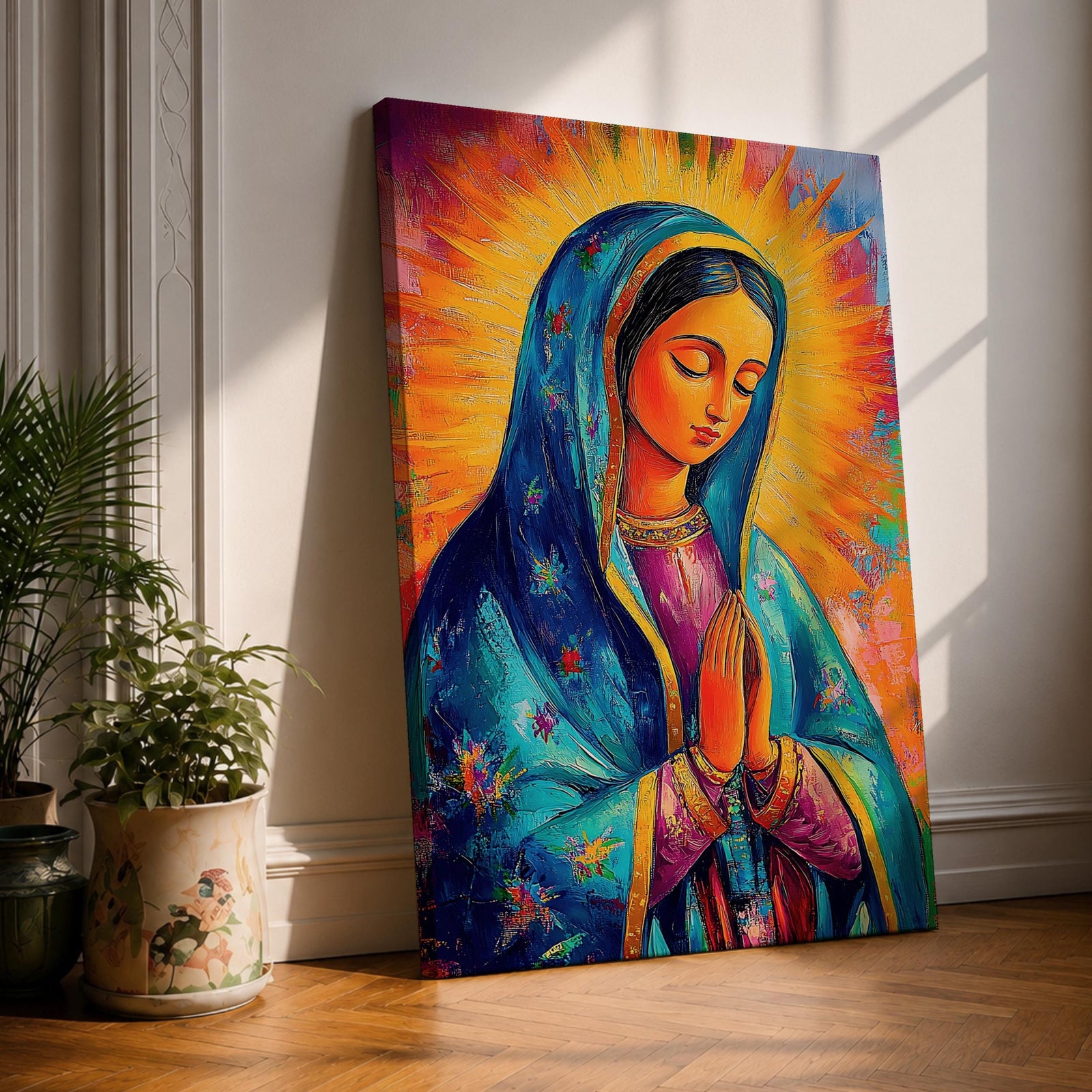 Colorful devotional painting of Our Lady of Guadalupe shown with hands clasped in prayer, wearing a blue star covered mantle over a rose dress while radiant golden rays form a glowing halo behind her figure. The composition presents the Virgin Mary in a vibrant painterly style with bold brushstrokes and centered sacred portrait.