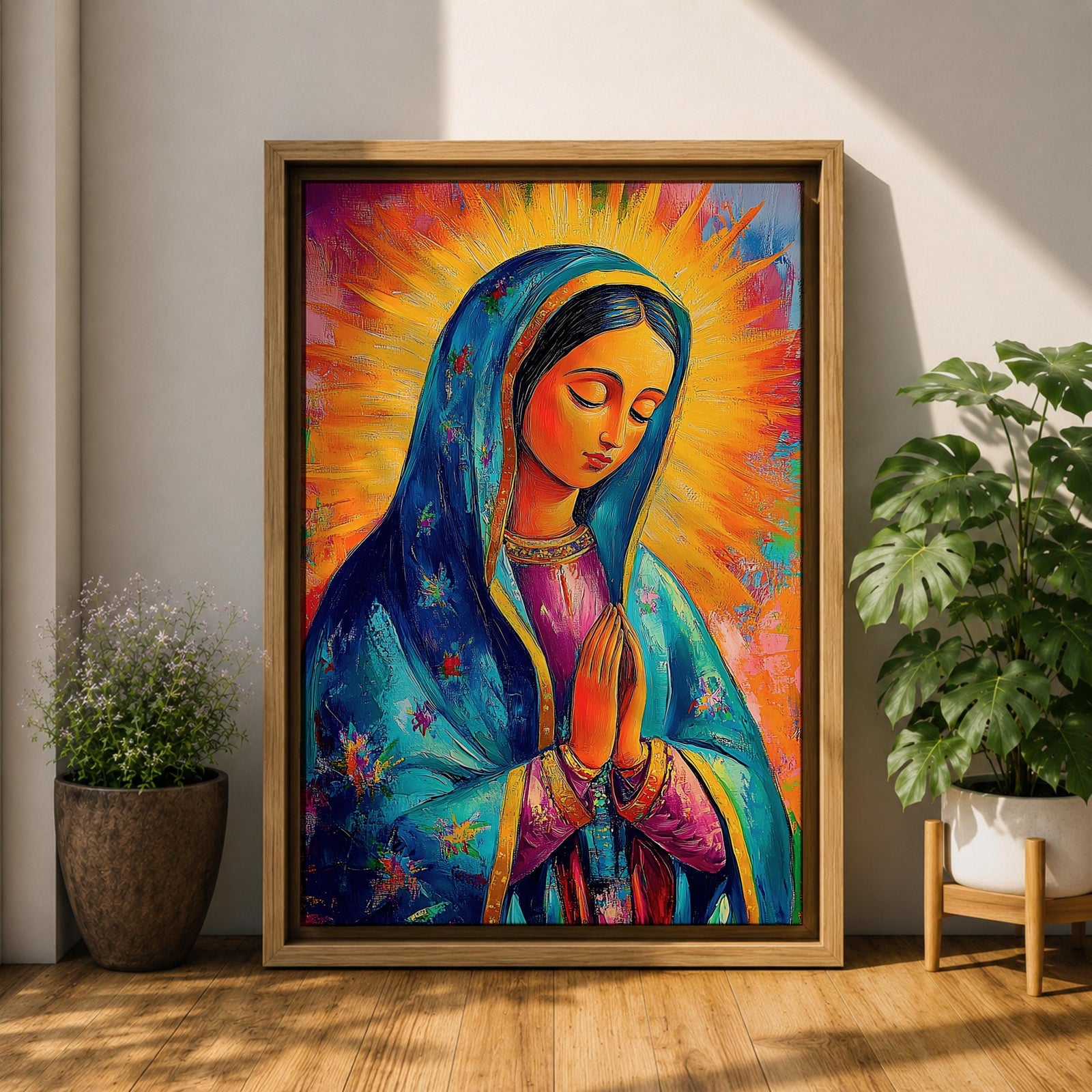 Colorful devotional painting of Our Lady of Guadalupe shown with hands clasped in prayer, wearing a blue star covered mantle over a rose dress while radiant golden rays form a glowing halo behind her figure. The composition presents the Virgin Mary in a vibrant painterly style with bold brushstrokes and centered sacred portrait.