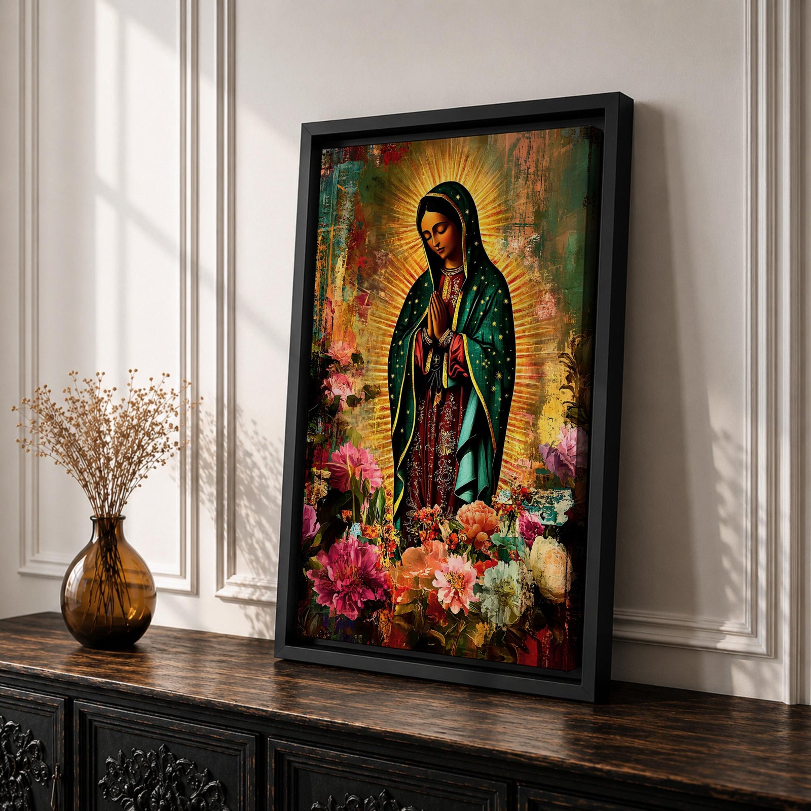 Devotional painting of Our Lady of Guadalupe standing with hands clasped in prayer, wearing a dark green star patterned mantle over a red dress and surrounded by radiant golden rays. The composition features colorful blooming flowers in the foreground framing the Virgin Mary in a vibrant painterly religious portrait.