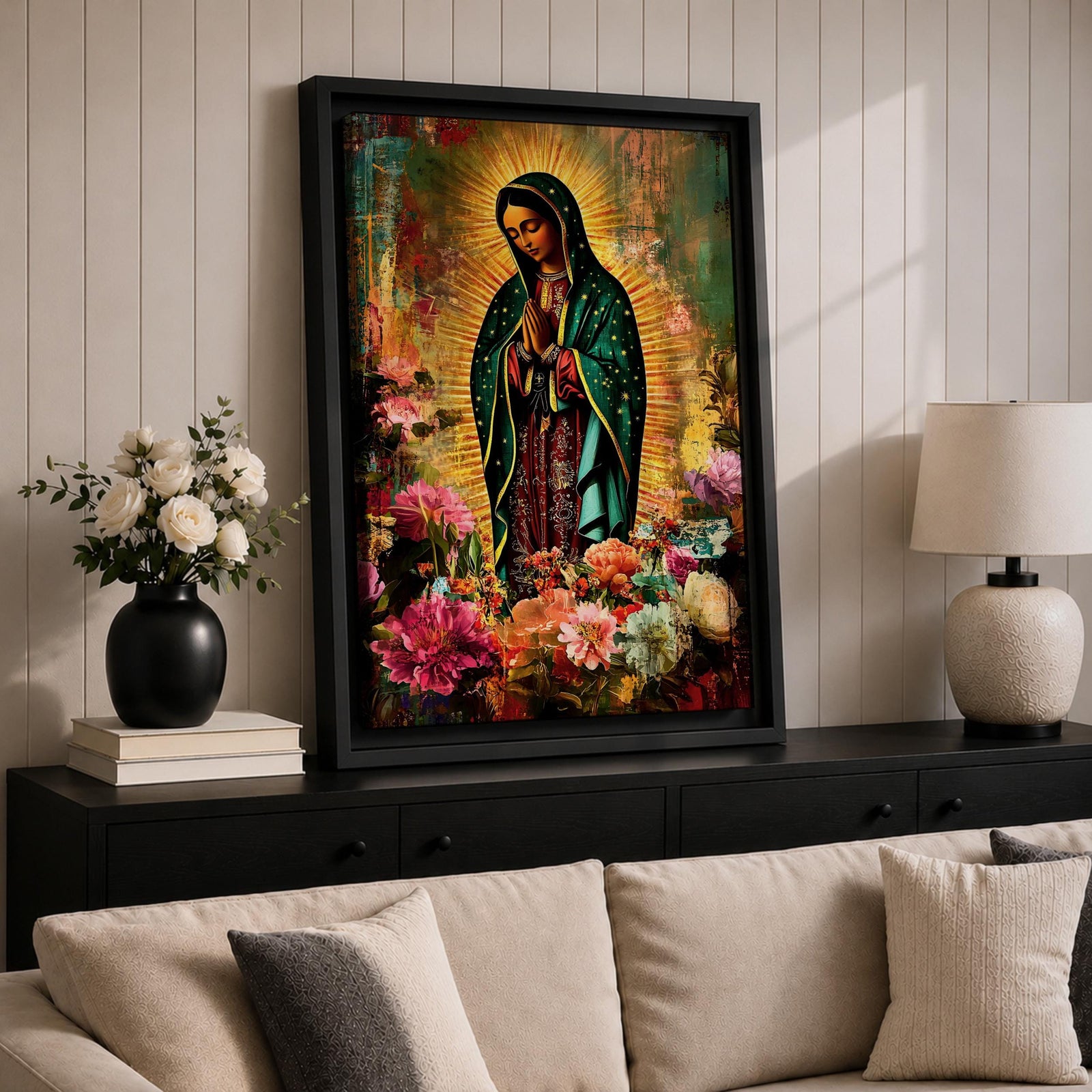 Devotional painting of Our Lady of Guadalupe standing with hands clasped in prayer, wearing a dark green star patterned mantle over a red dress and surrounded by radiant golden rays. The composition features colorful blooming flowers in the foreground framing the Virgin Mary in a vibrant painterly religious portrait.