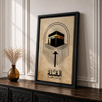 Minimalist Islamic artwork showing the Kaaba with flowing directional lines pointing toward it to symbolize the Qibla prayer direction, featuring Arabic calligraphy reading “Al-Qibla” beneath the geometric design, rendered in black and gold tones on a warm sepia parchment-style background.
