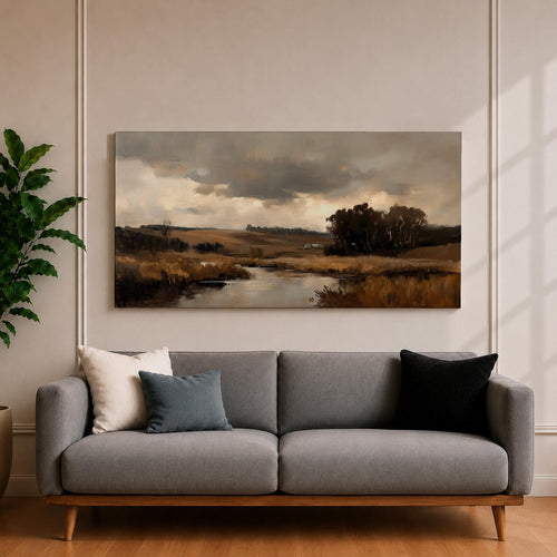 A panoramic countryside river landscape painting featuring a calm winding stream flowing through open rural fields with tall golden grasses and a distant farmhouse near a cluster of dark trees beneath a dramatic cloudy sky. The scene uses earthy browns and muted greens with soft painterly brushstrokes capturing a quiet pastoral prairie setting.