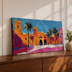 Panoramic painting of a Moroccan kasbah with tall palm trees and arched fortress gates rendered in bold palette knife brushstrokes. Bright orange, pink, and terracotta buildings contrast against a vivid blue sky, capturing the architecture of a Marrakech medina with textured walls and sunlit desert tones.