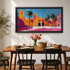 Panoramic painting of a Moroccan kasbah with tall palm trees and arched fortress gates rendered in bold palette knife brushstrokes. Bright orange, pink, and terracotta buildings contrast against a vivid blue sky, capturing the architecture of a Marrakech medina with textured walls and sunlit desert tones.