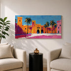 Panoramic painting of a Moroccan kasbah with tall palm trees and arched fortress gates rendered in bold palette knife brushstrokes. Bright orange, pink, and terracotta buildings contrast against a vivid blue sky, capturing the architecture of a Marrakech medina with textured walls and sunlit desert tones.