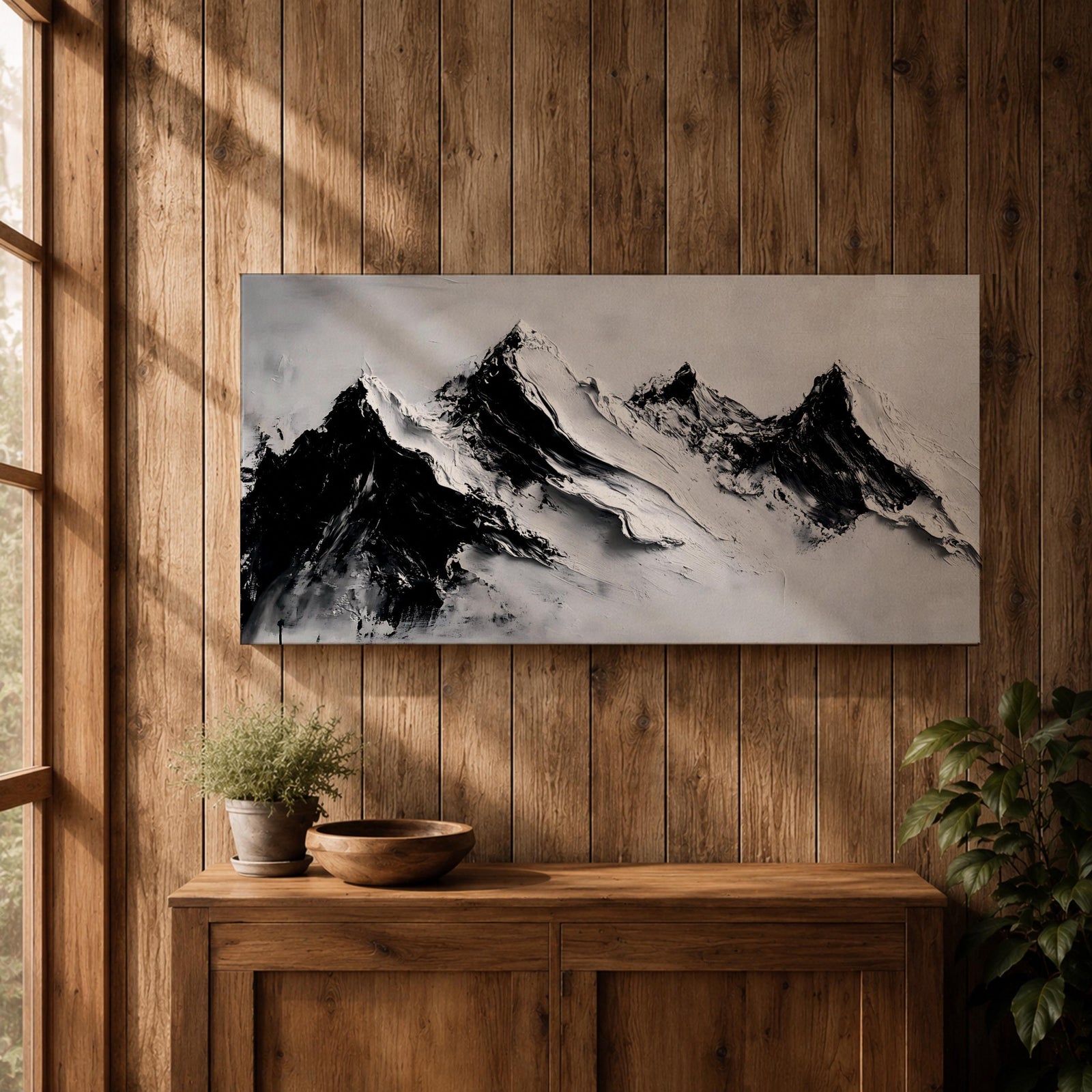 Panoramic black and white painting of alpine peaks with dramatic snowy mountains rising through mist and clouds. Thick textured brushstrokes create strong contrast between dark rocky ridges and bright snowfields, forming a minimalist monochrome mountain landscape stretching across a wide composition.