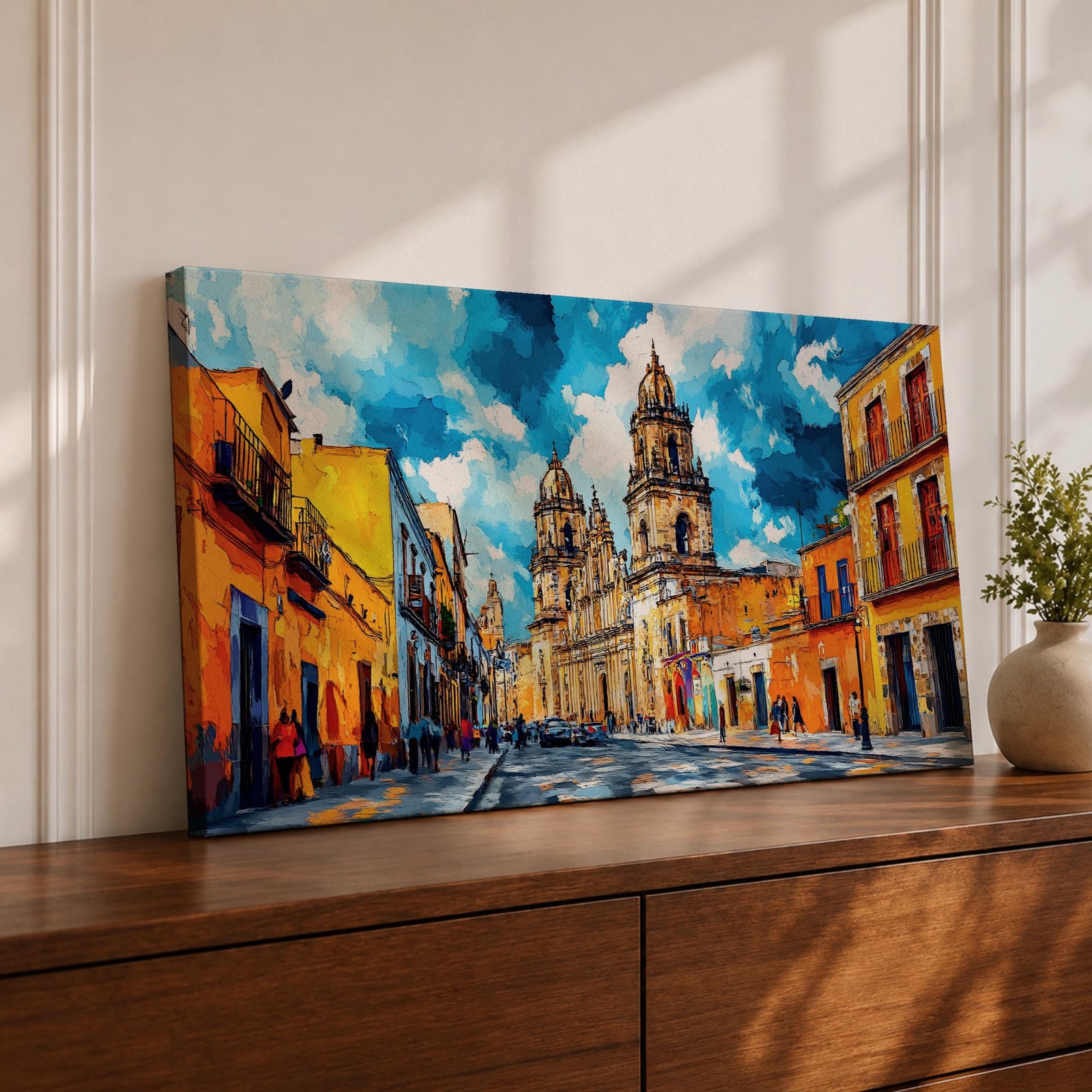 Panoramic painting of Oaxaca cathedral rising above a colorful colonial street lined with bright orange and yellow buildings. The historic Mexican architecture features twin cathedral towers beneath a dramatic blue sky with expressive painterly brushstrokes.