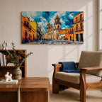 Panoramic painting of Oaxaca cathedral rising above a colorful colonial street lined with bright orange and yellow buildings. The historic Mexican architecture features twin cathedral towers beneath a dramatic blue sky with expressive painterly brushstrokes.