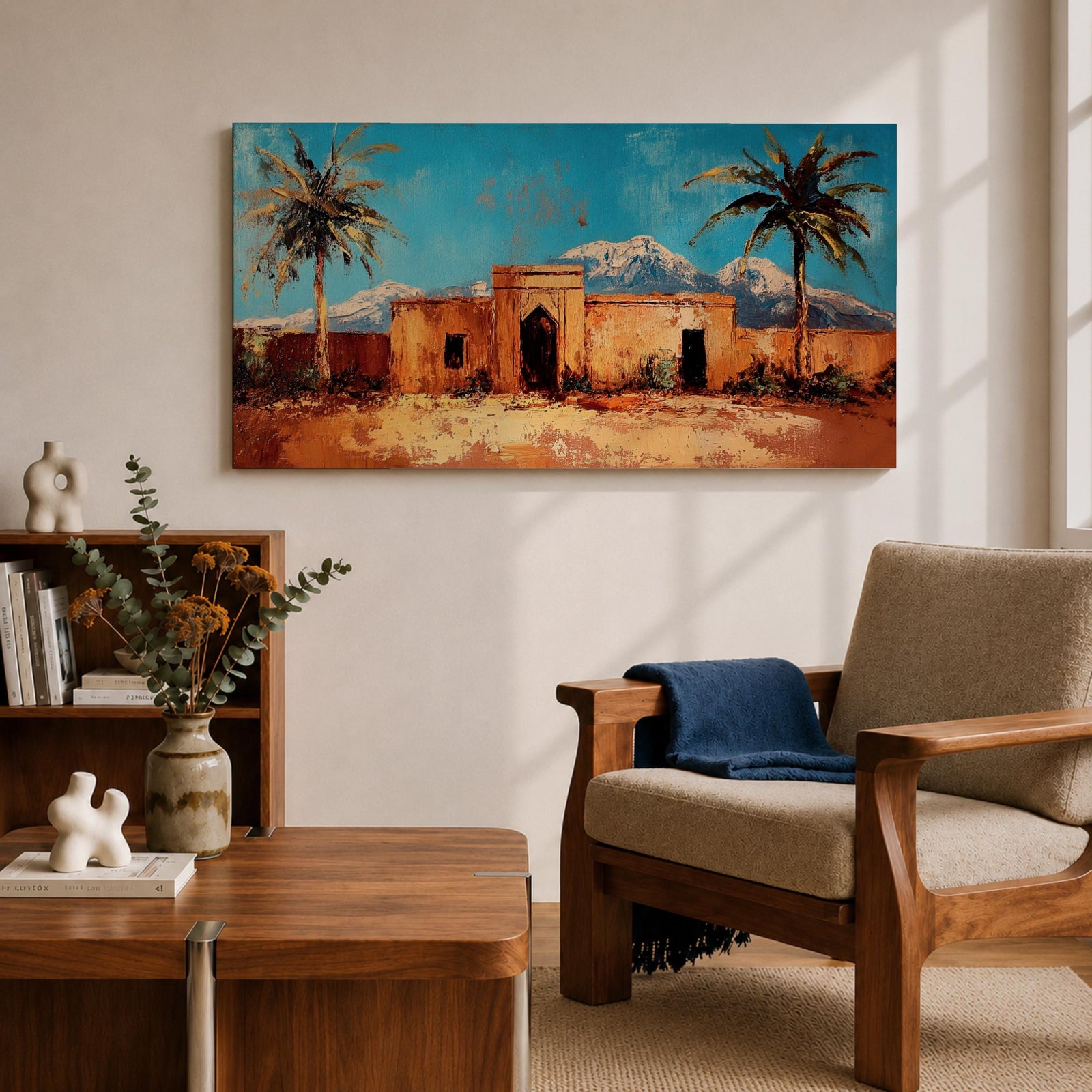 Panoramic painting of a Moroccan kasbah surrounded by palm trees in a desert oasis with the Atlas Mountains rising in the distance. The warm earthen architecture contrasts with a bright blue sky and textured brushstrokes capturing North African landscape scenery.