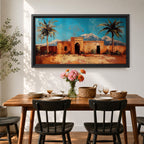 Panoramic painting of a Moroccan kasbah surrounded by palm trees in a desert oasis with the Atlas Mountains rising in the distance. The warm earthen architecture contrasts with a bright blue sky and textured brushstrokes capturing North African landscape scenery.