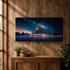 Panoramic night scene of the Dome of the Rock mosque in Jerusalem illuminated beneath a star filled sky and Milky Way galaxy. The golden dome reflects soft light across the courtyard while the historic Islamic architecture stands against the deep blue night horizon.