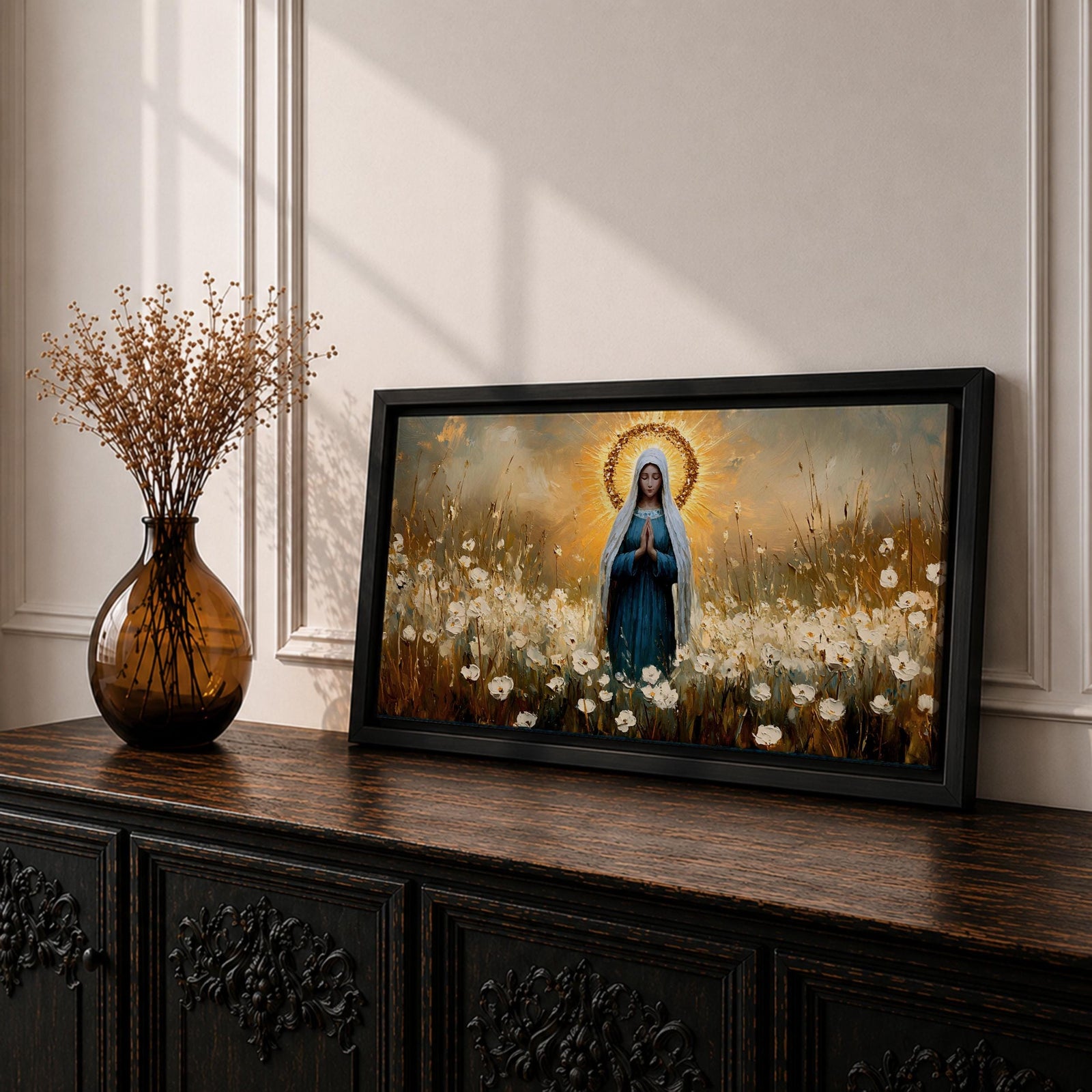 Panoramic painting depicting the Virgin Mary standing in a field of white flowers with hands gently clasped in prayer. A radiant golden halo surrounds her head while warm light fills the sky behind her, and soft brushstrokes capture flowing robes and delicate blossoms across the landscape.