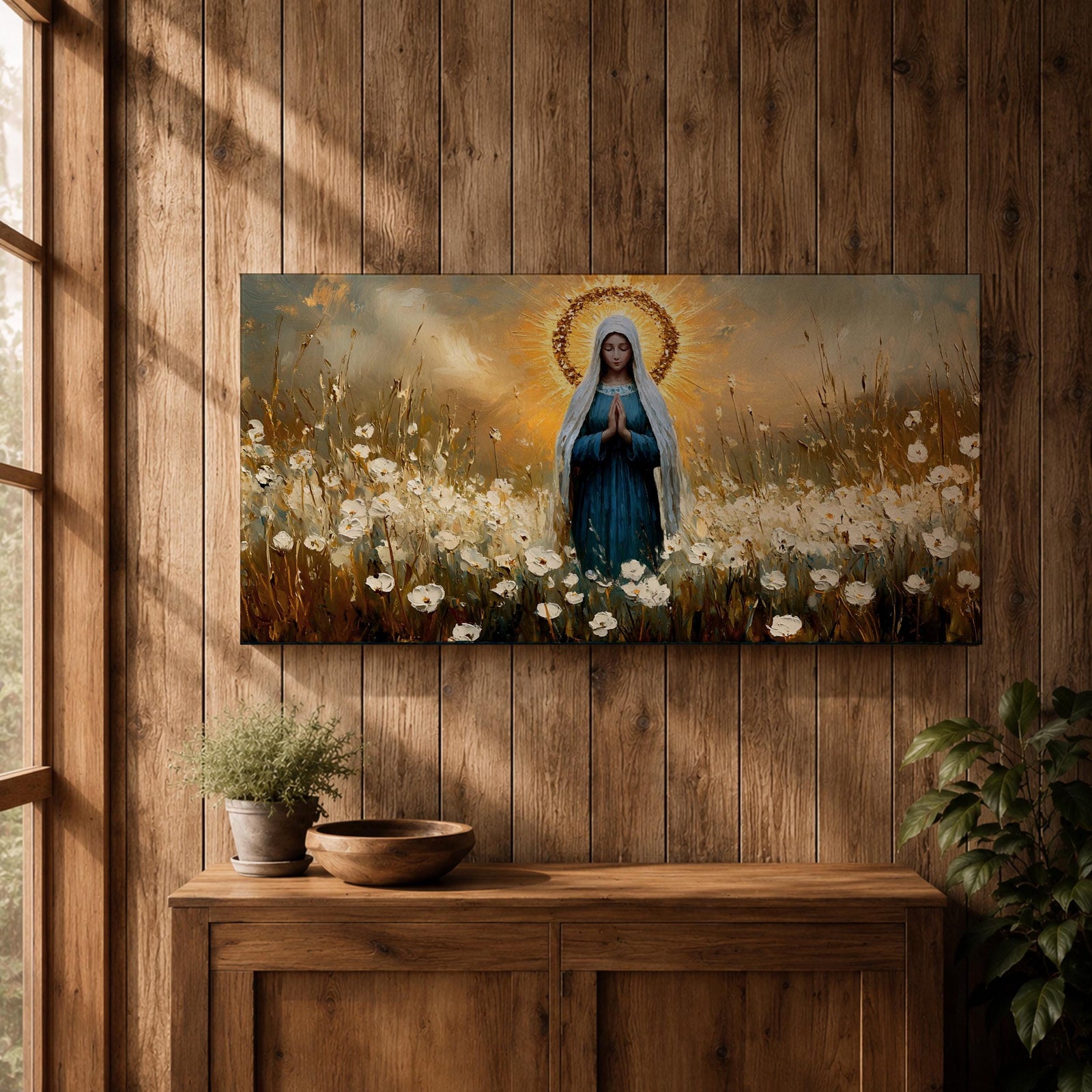 Panoramic painting depicting the Virgin Mary standing in a field of white flowers with hands gently clasped in prayer. A radiant golden halo surrounds her head while warm light fills the sky behind her, and soft brushstrokes capture flowing robes and delicate blossoms across the landscape.