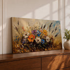 Panoramic painting depicting a vibrant cluster of wildflowers growing through tall meadow grasses. Bright blossoms in orange, blue, purple, and white rise from textured golden stems while loose expressive brushstrokes create movement across the floral arrangement and surrounding field.