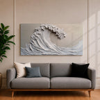 Panoramic textured relief artwork depicting a powerful ocean wave curling upward in sculpted layered forms. The cresting breaker is rendered with thick plaster like ridges and flowing contours in soft neutral tones, creating a minimalist seascape with depth and movement across the wide horizontal composition.