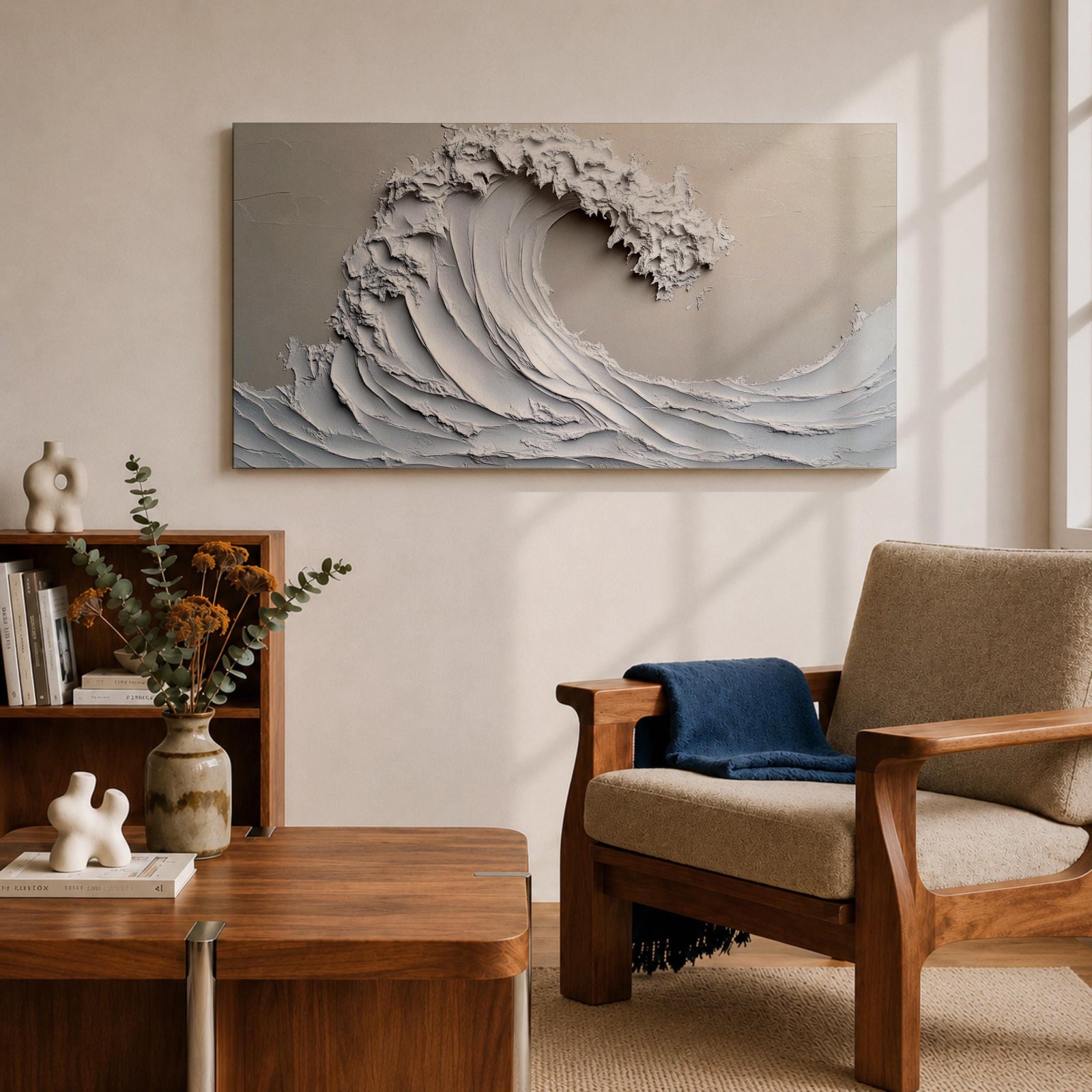 Panoramic textured relief artwork depicting a powerful ocean wave curling upward in sculpted layered forms. The cresting breaker is rendered with thick plaster like ridges and flowing contours in soft neutral tones, creating a minimalist seascape with depth and movement across the wide horizontal composition.