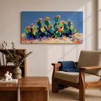 Panoramic painting of desert prickly pear cactus plants with bright pink and yellow blooming flowers growing across a colorful arid landscape. Thick palette knife brushstrokes create textured cactus pads vibrant blossoms and layered desert hills beneath a glowing sky forming a wide southwestern desert scene.