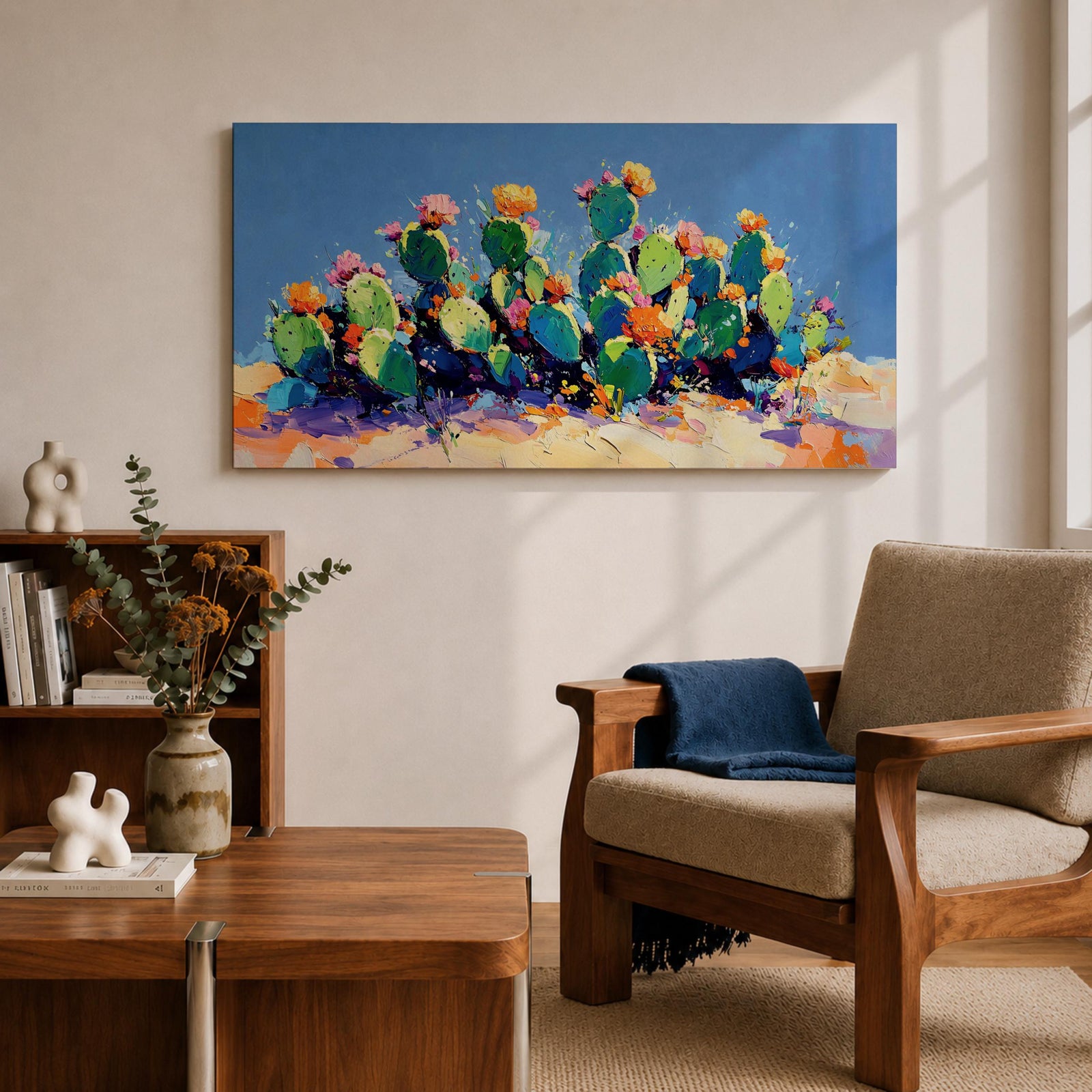 Panoramic painting of desert prickly pear cactus plants with bright pink and yellow blooming flowers growing across a colorful arid landscape. Thick palette knife brushstrokes create textured cactus pads vibrant blossoms and layered desert hills beneath a glowing sky forming a wide southwestern desert scene.