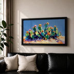 Panoramic painting of desert prickly pear cactus plants with bright pink and yellow blooming flowers growing across a colorful arid landscape. Thick palette knife brushstrokes create textured cactus pads vibrant blossoms and layered desert hills beneath a glowing sky forming a wide southwestern desert scene.