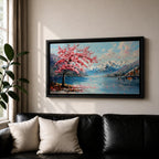 Panoramic painting of a cherry blossom tree in full bloom beside a calm mountain lake with snow covered peaks in the distance and soft clouds above. Pink petals drift across the water while thick palette knife brushstrokes create texture in the blossoms shoreline and reflections forming a wide spring landscape scene with bold color contrast.