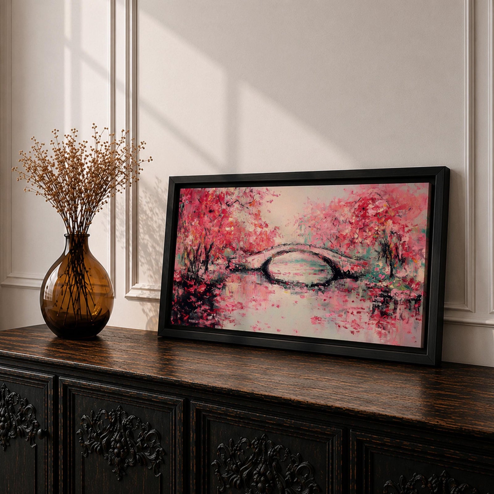 Panoramic painting of blooming cherry blossom trees with soft pink petals surrounding a curved bridge over calm water during spring. Layers of textured brushstrokes form clusters of blossoms drifting across the scene while reflections shimmer on the surface creating a wide Japanese inspired spring landscape composition.