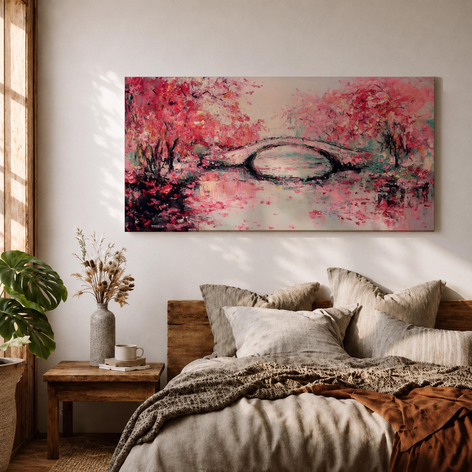 Panoramic painting of blooming cherry blossom trees with soft pink petals surrounding a curved bridge over calm water during spring. Layers of textured brushstrokes form clusters of blossoms drifting across the scene while reflections shimmer on the surface creating a wide Japanese inspired spring landscape composition.