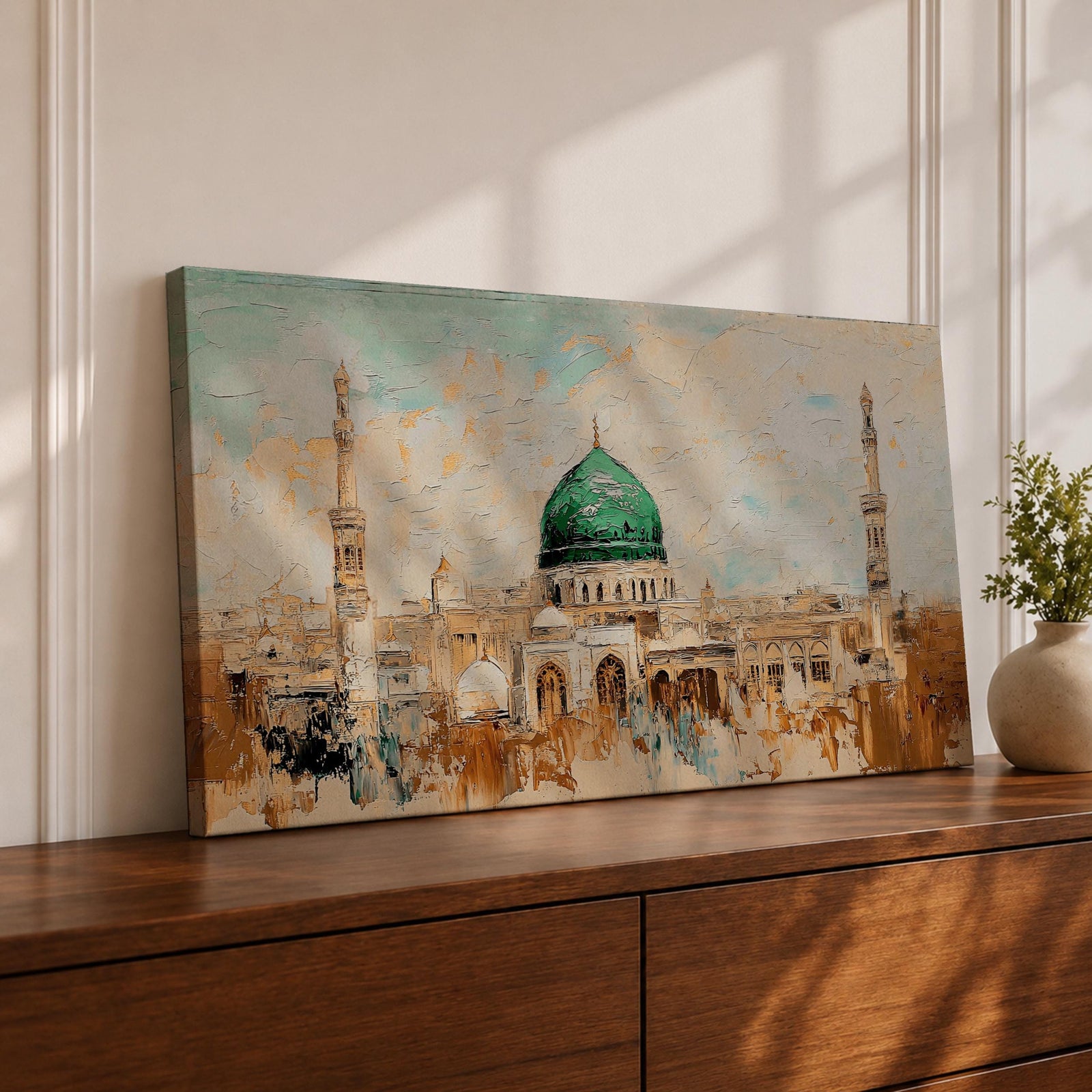 Panoramic abstract painting of Masjid Nabawi in Medina featuring the iconic green dome and two slender minarets rising above arches and mosque courtyards. The artwork uses thick textured brushstrokes in warm sand, gold, and cream tones with turquoise sky accents, highlighting the vibrant green dome in a wide horizontal composition.