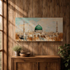 Panoramic abstract painting of Masjid Nabawi in Medina featuring the iconic green dome and two slender minarets rising above arches and mosque courtyards. The artwork uses thick textured brushstrokes in warm sand, gold, and cream tones with turquoise sky accents, highlighting the vibrant green dome in a wide horizontal composition.