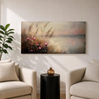 Panoramic landscape painting of soft pink wildflowers and tall grasses growing along a calm lakeshore. The scene features delicate meadow blooms in the foreground with textured brushstrokes and warm earthy tones, fading into a misty reflective lake and distant horizon under a gentle sky.