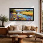 Panoramic landscape painting of a winding river flowing through a countryside meadow filled with colorful wildflowers. A small stone bridge arches over the water while fields, cottages, and rolling hills stretch into the distance under a bright sky, rendered with vibrant textured brushstrokes.