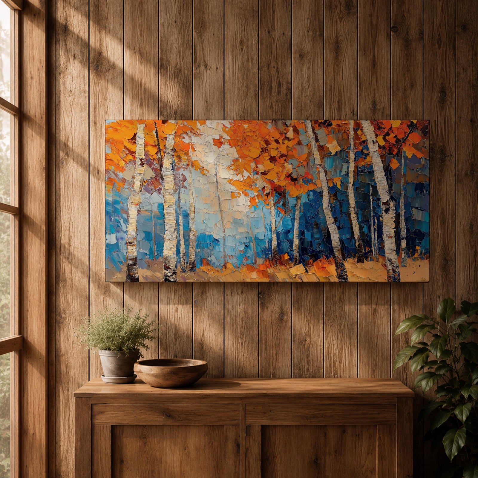Panoramic painting of tall white birch trees with textured bark standing among vivid orange autumn foliage. Thick palette knife brushstrokes create layered leaves and forest floor tones, with warm golden light filtering through the canopy against cool blue woodland shadows.