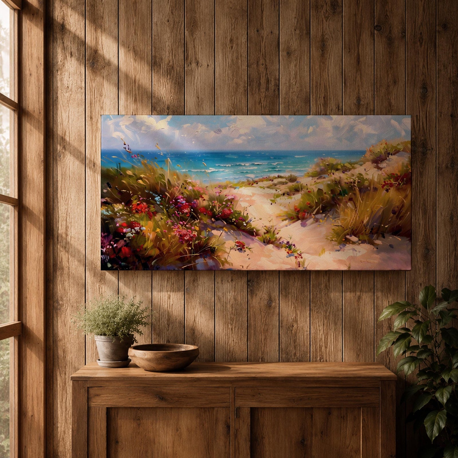 Panoramic coastal landscape painting of sandy beach dunes leading toward turquoise ocean waves under a bright sky. Tall grasses and colorful wildflowers line a winding path through the dunes, painted with loose textured brushstrokes capturing sunlight, sea breeze, and shoreline scenery.