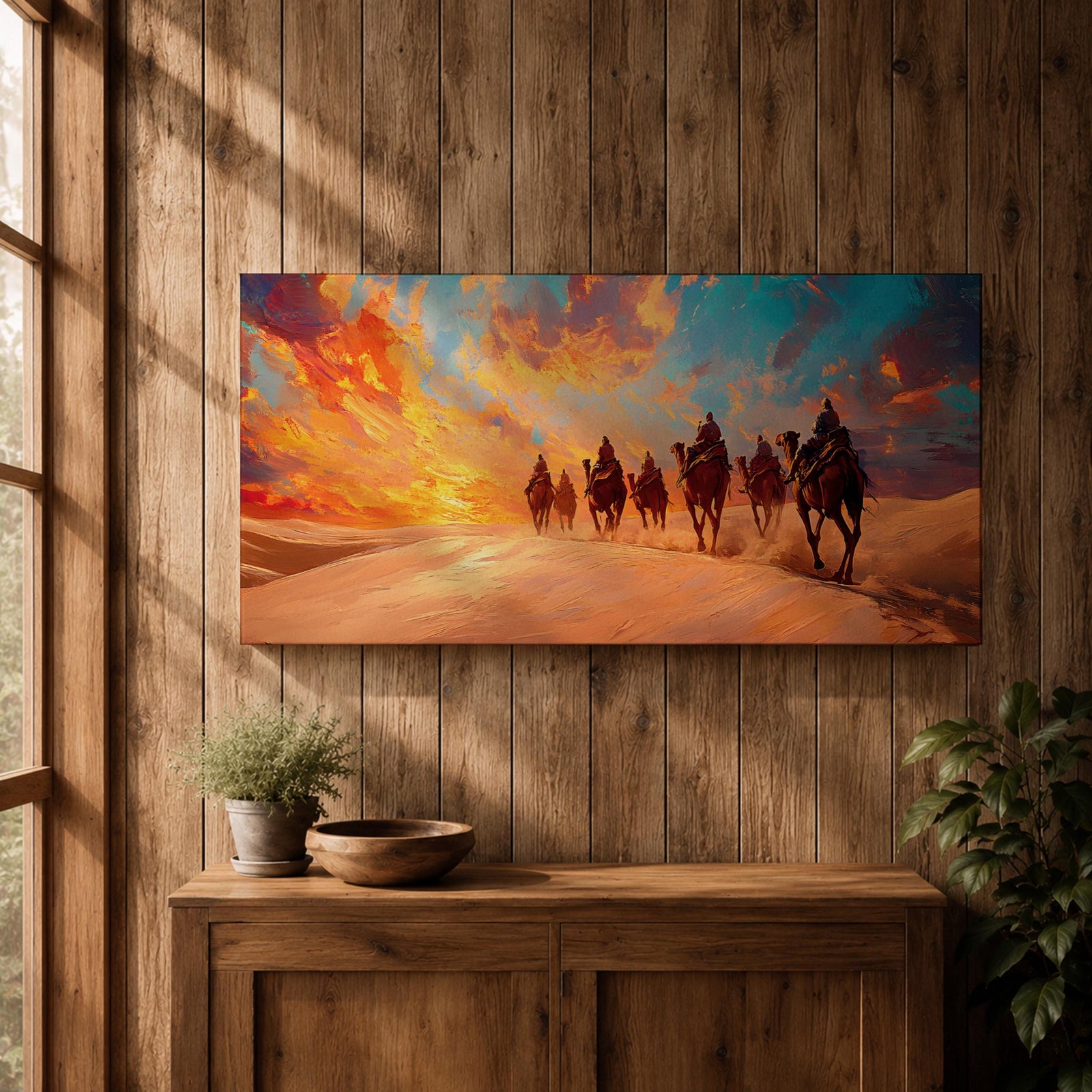 Panoramic painting of a camel caravan traveling across golden desert dunes at sunset with riders silhouetted beneath a vibrant dramatic sky.