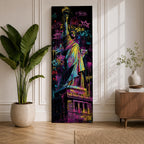 A tall narrow artwork of the Statue of Liberty rendered in vibrant graffiti style with bold neon colors, layered spray paint textures and street tags across the background, featuring dynamic splashes of pink, yellow, blue and green with high contrast outlines in an urban pop art composition.