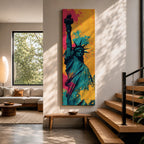 A tall narrow artwork of the Statue of Liberty shown from a low angle with the torch raised, rendered in bold pop art style with vibrant teal tones contrasted by bright pink and yellow paint splashes, featuring dynamic splatter textures and graphic shading in a modern abstract urban composition.