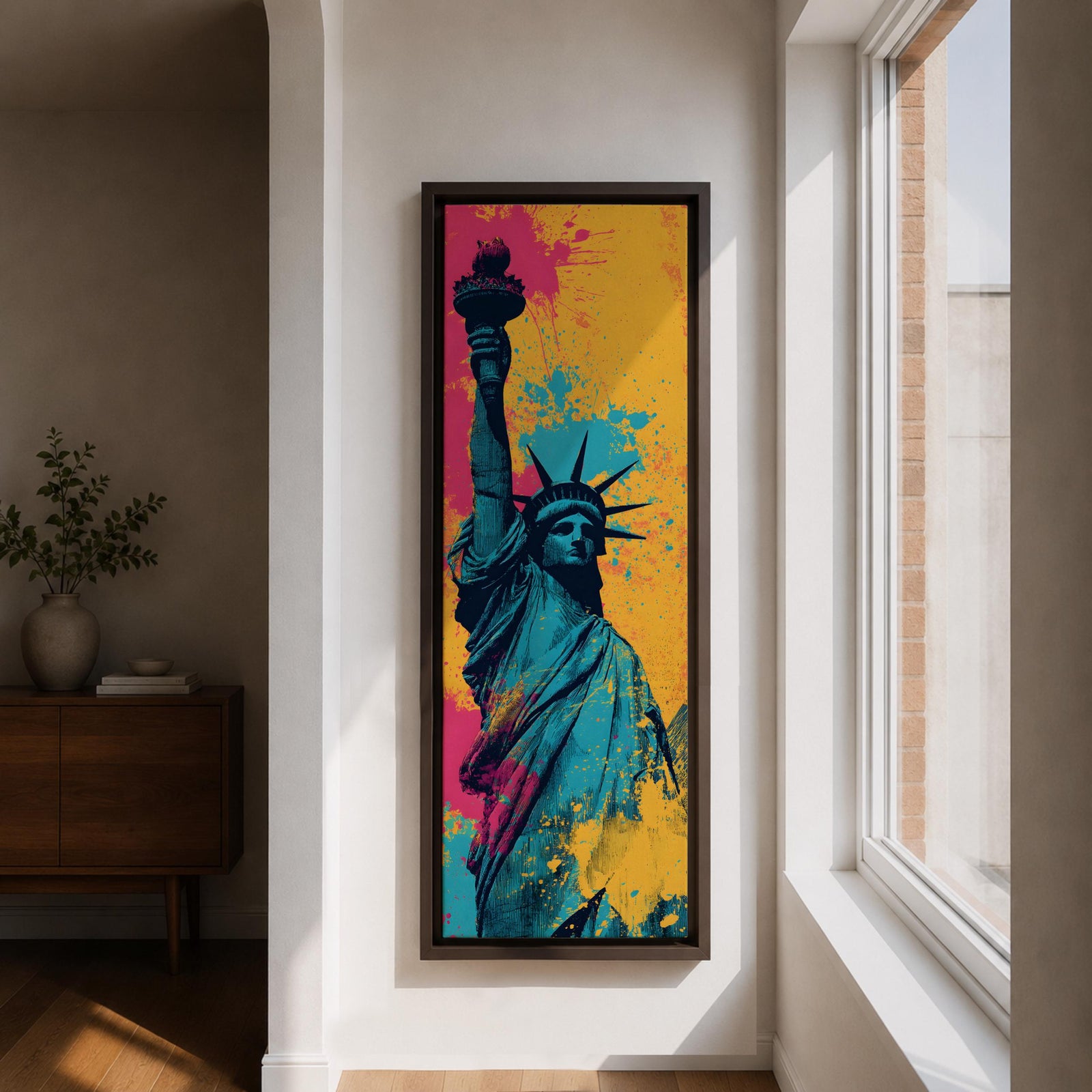 A tall narrow artwork of the Statue of Liberty shown from a low angle with the torch raised, rendered in bold pop art style with vibrant teal tones contrasted by bright pink and yellow paint splashes, featuring dynamic splatter textures and graphic shading in a modern abstract urban composition.