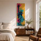 A tall narrow artwork of the Statue of Liberty shown from a low angle with the torch raised, rendered in bold pop art style with vibrant teal tones contrasted by bright pink and yellow paint splashes, featuring dynamic splatter textures and graphic shading in a modern abstract urban composition.