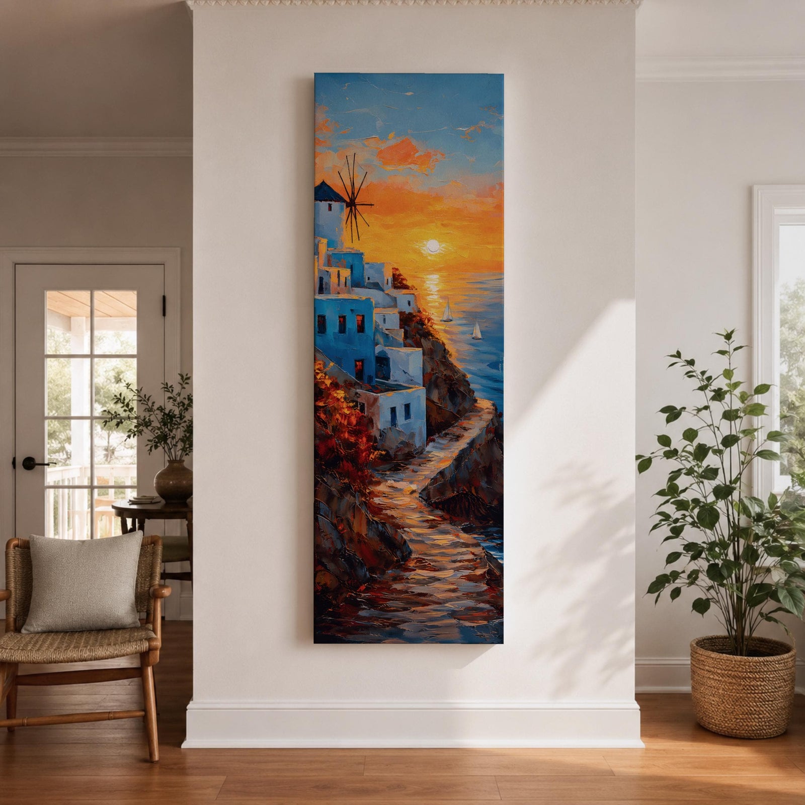 A tall vertical painting depicts a Santorini coastal scene with whitewashed buildings perched along a cliffside, a winding stone path leading toward the sea, and a glowing sunset casting warm orange and gold light across the sky and water, with a windmill silhouette and small sailboats adding depth to the vibrant Mediterranean composition.