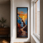 A tall vertical painting depicts a Santorini coastal scene with whitewashed buildings perched along a cliffside, a winding stone path leading toward the sea, and a glowing sunset casting warm orange and gold light across the sky and water, with a windmill silhouette and small sailboats adding depth to the vibrant Mediterranean composition.