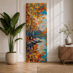 Tall vertical landscape painting of slender birch trees with golden autumn leaves along a calm reflective river. Thick palette knife oil brushstrokes create vibrant fall colors of orange, yellow, and blue with the trees mirrored in the water while distant forest and sky appear softly textured in the background.