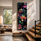 Tall vertical botanical artwork featuring glowing neon flowers in vibrant rainbow colors against a deep black background. Large luminous blossoms in pink, orange, purple, and blue are surrounded by detailed leaves, creating a modern floral composition with bold contrast and iridescent color transitions.
