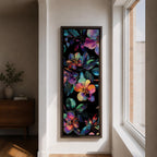 Tall vertical botanical artwork featuring glowing neon flowers in vibrant rainbow colors against a deep black background. Large luminous blossoms in pink, orange, purple, and blue are surrounded by detailed leaves, creating a modern floral composition with bold contrast and iridescent color transitions.