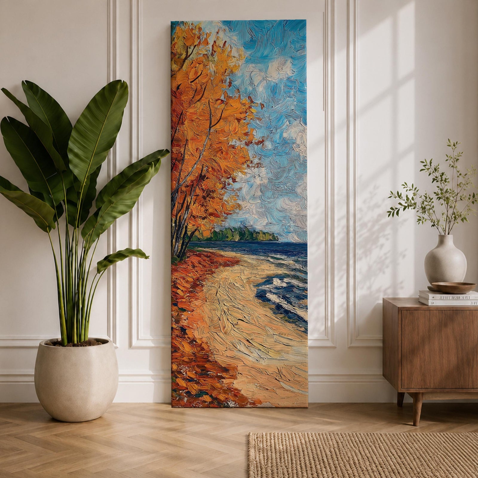 Tall vertical landscape painting of an autumn shoreline with golden orange trees lining a sandy beach beside deep blue water. Thick palette knife brushstrokes create textured waves, falling leaves, and swirling sky patterns while the curved shoreline leads toward a distant forest horizon.