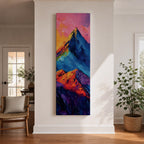 Tall vertical abstract mountain painting with bold colorful peaks in vibrant blue, red, purple, and yellow tones. Thick impasto brushstrokes create dramatic alpine ridges beneath a bright pink and orange sky, forming a modern expressive mountain landscape.