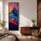 Tall vertical abstract mountain painting with bold colorful peaks in vibrant blue, red, purple, and yellow tones. Thick impasto brushstrokes create dramatic alpine ridges beneath a bright pink and orange sky, forming a modern expressive mountain landscape.