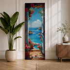 Tall vertical coastal painting showing an Italian ocean view framed by an open doorway with pink flowers and potted plants. The bright Mediterranean sea stretches toward rocky cliffs and a distant sailboat beneath a clear blue sky.