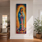 Long vertical painting of the Virgin Mary standing in prayer with hands together, wearing a blue mantle over a pink robe and surrounded by radiant golden rays. Colorful flowers gather at her feet while expressive brushstrokes and vibrant tones create a devotional depiction inspired by the Virgen de Guadalupe iconography.