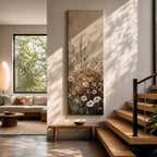 Long vertical painting of delicate wildflowers and daisies rising through tall meadow grasses in soft neutral tones. White petals with warm golden centers appear among slender stems and subtle foliage against a muted beige sky creating a calm botanical meadow composition with layered natural textures.