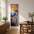Long vertical painting of a Santorini coastal village with whitewashed buildings and a blue dome church overlooking the sea at sunset. A stone pathway descends between bright white walls toward the shoreline while golden sunlight reflects across calm water and warm clouds fill the sky.