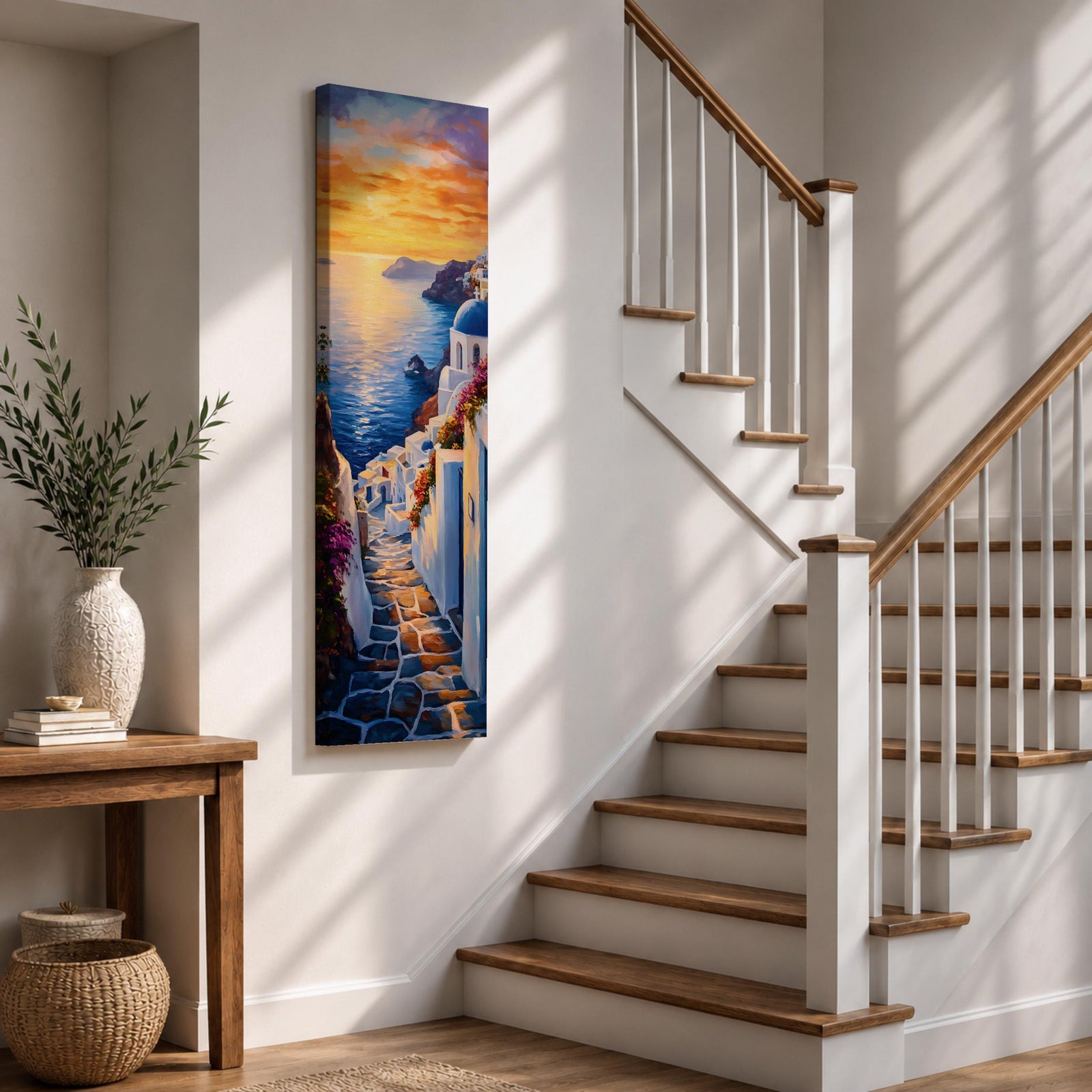 Long vertical painting of a Santorini coastal village with whitewashed buildings and a blue dome church overlooking the sea at sunset. A stone pathway descends between bright white walls toward the shoreline while golden sunlight reflects across calm water and warm clouds fill the sky.